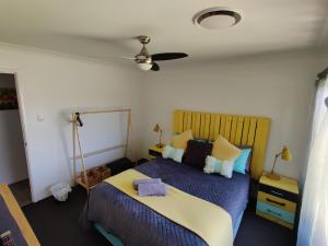 a bedroom with a bed with a blue comforter at Stylish Colourfull Getaway in Margaret River Town