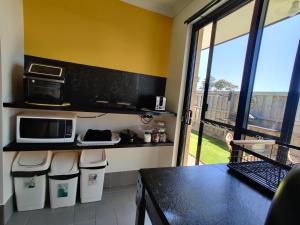a kitchen with a counter top and a microwave at Stylish Colourfull Getaway in Margaret River Town