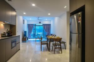 a kitchen and dining room with a table and a refrigerator at Eaton KLCC Suites By Elite in Kuala Lumpur