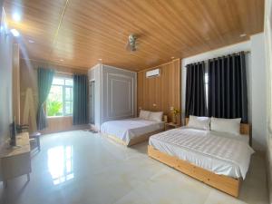 Un dormitorio con dos camas y techo de madera. en Bảo Lạc - Sunny Homestay, en Bảo Lạc