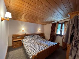 a bedroom with a bed and a wooden ceiling at Fleckalm Chalets in Kirchberg in Tirol