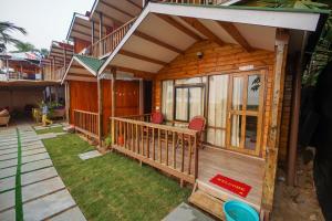 a wooden house with a porch and a balcony at Sonho do Mar in Agonda