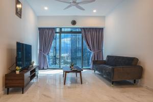 a living room with a couch and a large window at Eaton KLCC Suites By Elite in Kuala Lumpur