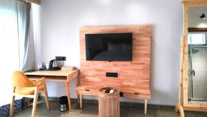 a room with a desk and a television on a wall at V Hotels and Resorts in Chīrāla