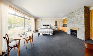 a bedroom with a bed and a table and a fireplace at Mt Michael Lodge in Cromwell