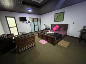a bedroom with a bed and a table and a couch at Hotel Green View Buttala in Buttala