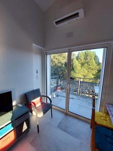 een woonkamer met uitzicht op een balkon bij Appartement 50m2 au cœur de sussargues in Sussargues