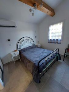 een slaapkamer met een bed in een kamer met een raam bij Appartement 50m2 au cœur de sussargues in Sussargues