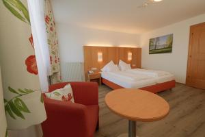 a hotel room with a bed and a table and a chair at Hotel Haberl - Attersee in Attersee am Attersee