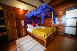 a bedroom with a bed with a canopy at Jardim a Mar in Agonda