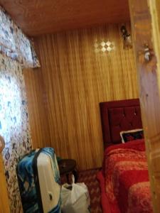 una habitación de hotel con una cama y una maleta en B ,heritage luxury houseboat, en Srinagar