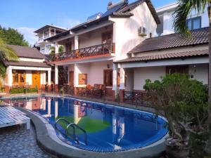 a swimming pool in front of a house at Nhat Huy Bungalow Phu Quoc in Phú Quốc