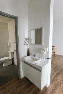 a white bathroom with a sink and a toilet at G Residence - 2BR Family Suite Barrington Night Market - 3 in Brinchang