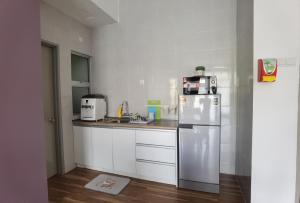 a small kitchen with a refrigerator and a sink at G Residence - 2BR Family Suite Barrington Night Market - 3 in Brinchang