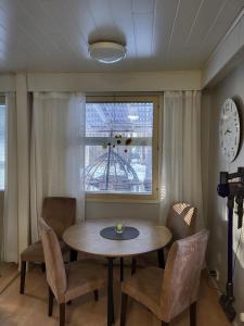 a dining room with a table and chairs and a clock at Rivitaloasunto Kittilässä in Kittilä