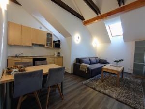 a kitchen and living room with a table and a couch at PUŠIES namai in Nida