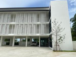 a white building with a car parked in the courtyard at IKKYU2 Angthong อิคคิว2 in Ang Thong