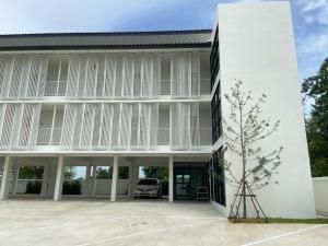 un edificio bianco con un'auto parcheggiata nel cortile di IKKYU2 Angthong อิคคิว2 a Ang Thong