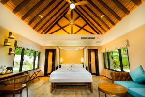 1 dormitorio con cama blanca y sofá en H Resort - The Coral Cliff, en Calape