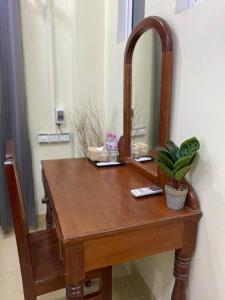 a wooden dressing table with a mirror and a plant at Nika's House in Siem Reap
