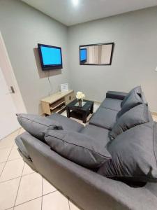 uma sala de estar com um sofá e uma televisão de ecrã plano em Pamuzinda Airbnb at Urban Cove em Nelspruit