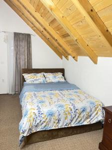 ein Schlafzimmer mit einem Bett und einer Holzdecke in der Unterkunft Bajka na dan two bedroom apartment in Bosanska Gradiška