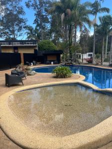 una gran piscina con una fuente en un patio en Batemans Bay North Bush Cottages, en Benandarah