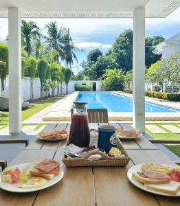 a table with plates of food on it next to a pool at 1949 Dreamy Home in Panglao