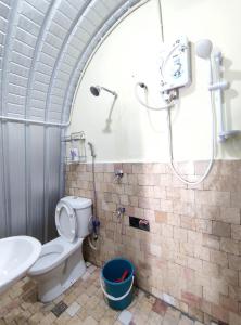 a bathroom with a shower and a toilet and a sink at D' Limbai Cottage in Ranau