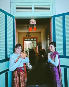 twee vrouwen buiten een huis met een vlieger bij The White House in Chiang Khan