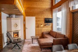 a living room with a couch and a fireplace at Hotel Iso-Syöte in Syöte