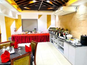 Hotel West Valley Dhaka في داكا: مطعم عليه طاولة عليها زهور حمراء