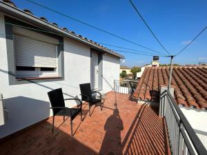 un patio con 2 sedie e un tavolo su una casa di Casa Grabo a Cors