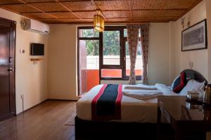 1 dormitorio con cama y ventana grande en Tulaja Boutique Hotel, en Bhaktapur