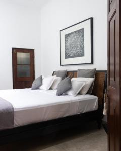 - une chambre avec un lit doté de draps et d'oreillers blancs dans l'établissement "27" Spathodea- Oasis in the City, à Colombo