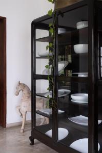 a glass display case with plates and a horse in the background at "27" Spathodea- Oasis in the City in Colombo