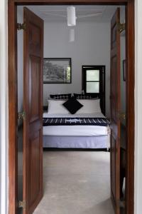 sypialnia z dużym łóżkiem z białą pościelą w obiekcie "27" Spathodea- Oasis in the City w Kolombo