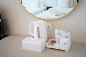 a white hair dryer sitting on a counter in front of a mirror at Herry Residence in Chiang Mai