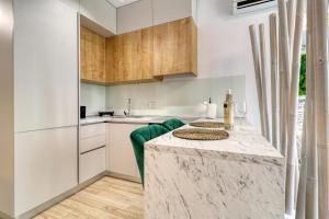 a kitchen with white cabinets and a marble counter top at Herastrau Luxury Studios in Bucharest +13 photos