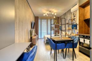 um quarto com uma cama, uma mesa e cadeiras em Herastrau Luxury Studios em Bucareste