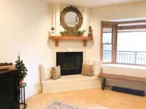 a living room with a fireplace and a mirror at Bear Creek Lodge 111A by Alpine Lodging Telluride in Telluride
