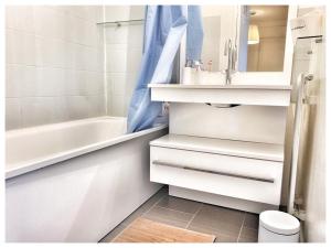 a bathroom with a sink and a tub and a toilet at Modern & Chic Appartement- GoodVibes Paris in Gonesse