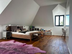 - une chambre mansardée avec un grand lit dans l'établissement Trierer Heide - Architektur zum wohl fühlen, à Trèves