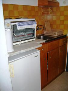 a kitchen with a microwave on top of a refrigerator at Natasa and Spiros in Paleokastritsa