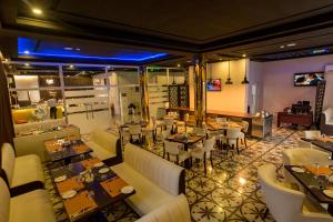 Rollace Hotel في إيكيجا: مطعم فيه طاولات وكراسي في الغرفة