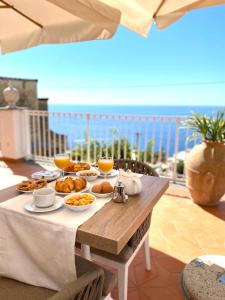 una mesa con comida y vistas al océano en La Bizantina Luxury Villa, en Positano