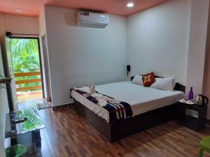 a bedroom with a bed in a room with a window at Kalapani Nest in Port Blair