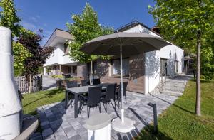 a patio with a table and an umbrella at wohn.genuss app traumhaus in Schladming