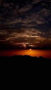 un tramonto con il sole che tramonta nel cielo di Petra Hill a Wadi Musa