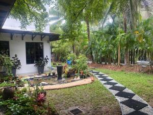 um jardim em frente a uma casa com um caminho em Aika Homestay em Shah Alam